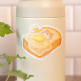 Muffinmaru about to enjoy a nice breakfast in bed that Devyegg prepared for him. The best way to start your day is with some toasty bread. The matte coating on this sticker gives it a premium soft touch and the backing paper is cut for an easy peeling experience.

Dimensions: 2.5” x 1.8” (6.3cm x 4.7cm)
Material: PP
Waterproof