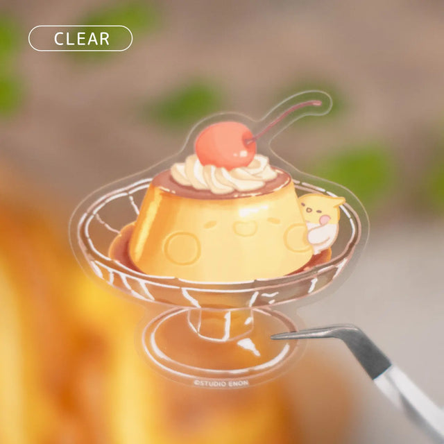 A premium clear sticker of Devyegg serving up a large Muffinmaru pudding. Devyegg is here to bring an extra serving of pudding and sweetness into your life with this delightful sticker. Clear stickers give off a refreshing look and are particularly striking on translucent surfaces. Comes with a removable white paper backing.

Approximate Dimensions: 2.4” x 2.5” (6.1cm x 6.4cm)
Material: Clear PET
Waterproof
Quantity: 1 sticker
