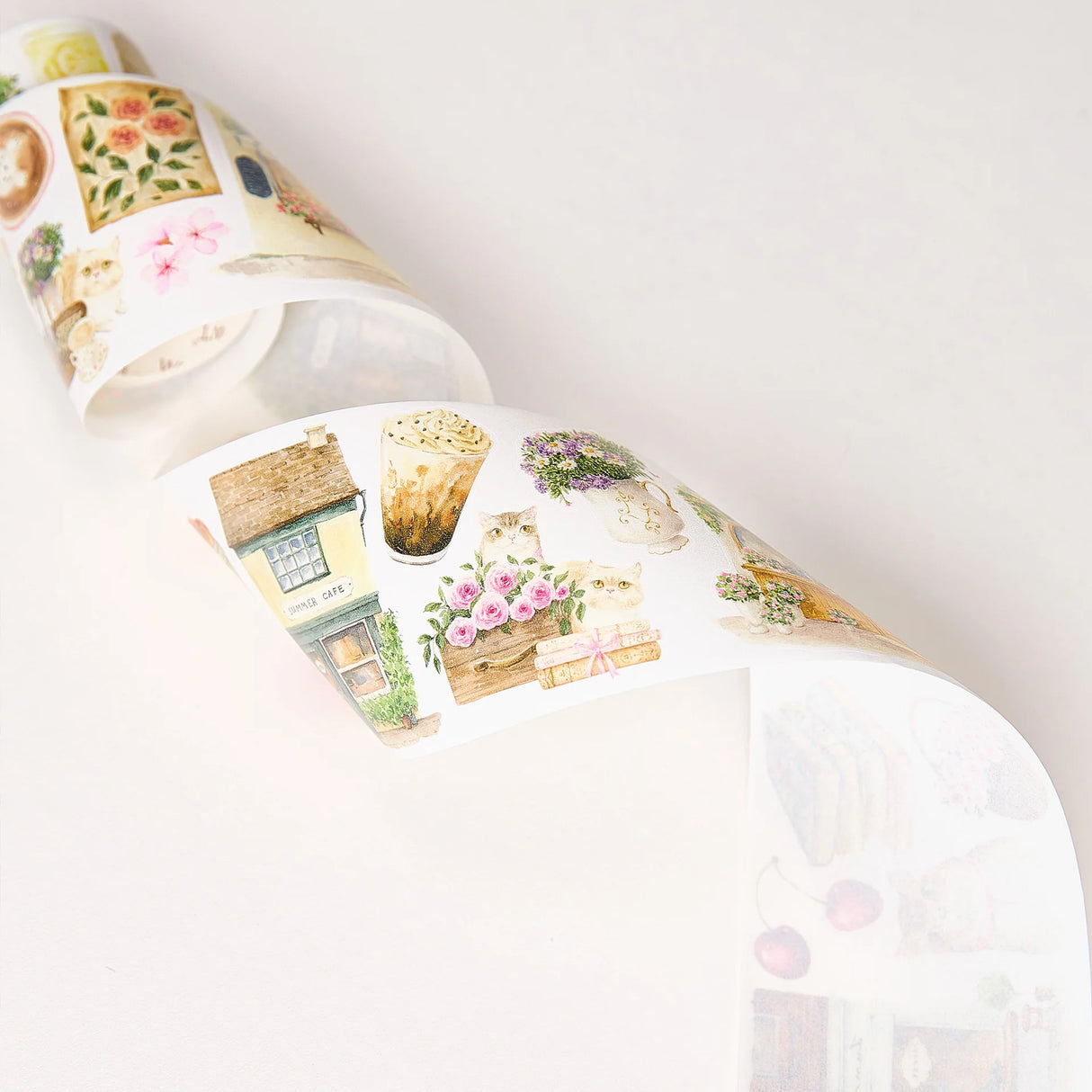 Step into a world where nature and comfort collide. Our Summer Café Wide Tape transforms your stationery into a bustling garden bistro, teeming with life, blooming flowers, and the true owners of the cafe: the cats.

This whimsical design weaves together the architecture of charming coffee shops with the wild beauty of summer florals. Nestled among the potted plants and open doors, you’ll find hand-painted cats exploring, sleeping, and playing.&nbsp;
