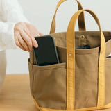 The SUPERIOR LABOR Mini Tote Bag

A simple, timeless canvas bag designed for everyday life.

Its compact size is just right for daily essentials, while the four outer pockets keep your glasses, keys, favorite pens, or notebook neatly organized.

They make it easy to stay tidy and add a touch of extra storage without changing the clean look of the bag.

Size: W37×H23.5×D12.5cm
Canvas Products
Painted areas may be affected by friction or water, which can cause color transfer. Please handle with care.