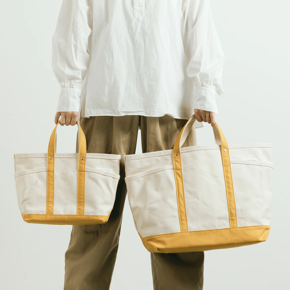 The SUPERIOR LABOR Mini Tote Bag

A simple, timeless canvas bag designed for everyday life.

Its compact size is just right for daily essentials, while the four outer pockets keep your glasses, keys, favorite pens, or notebook neatly organized.

They make it easy to stay tidy and add a touch of extra storage without changing the clean look of the bag.

Size: W37×H23.5×D12.5cm
Canvas Products
Painted areas may be affected by friction or water, which can cause color transfer. Please handle with care.