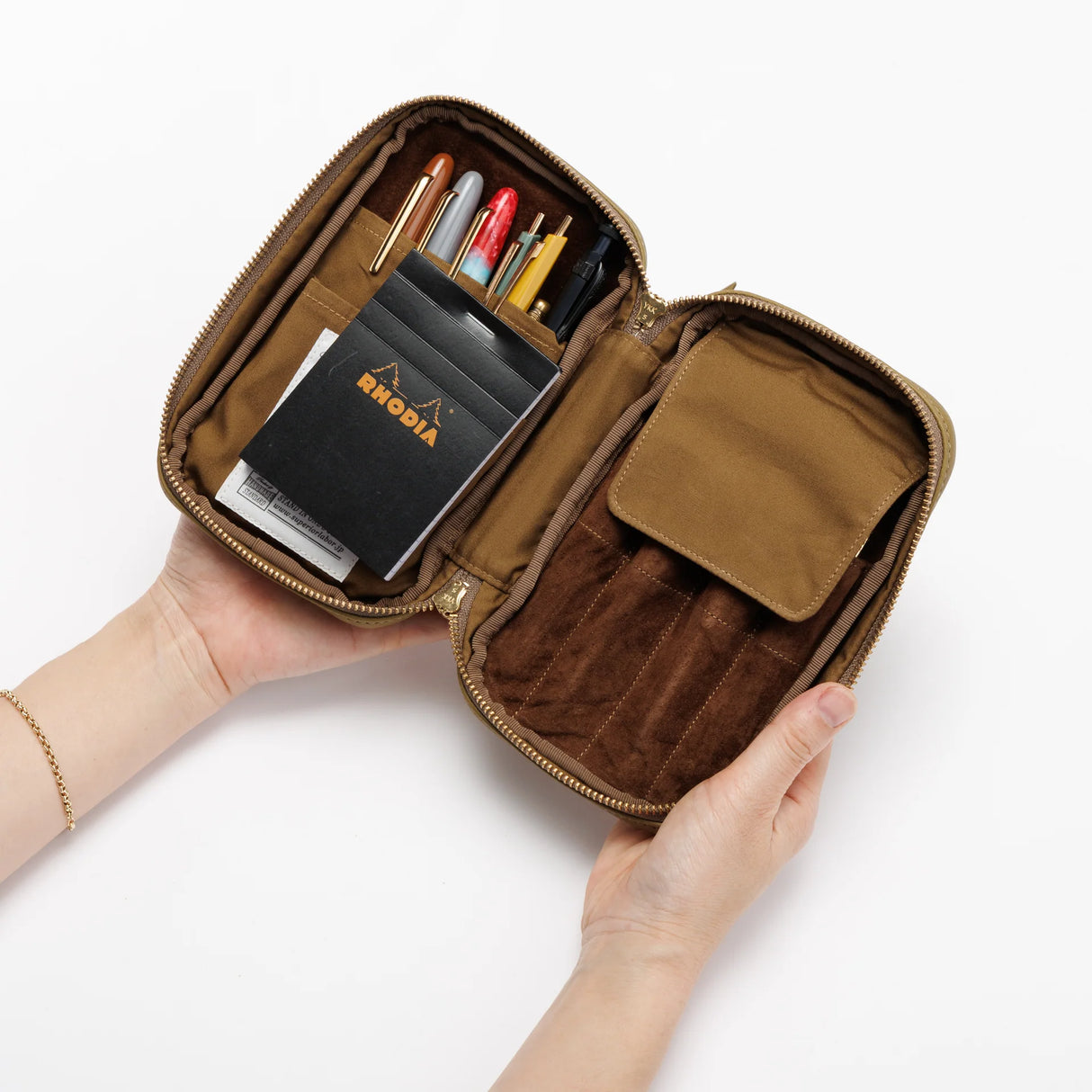 We crafted this leather case for those who love to write —for people who value the quiet moments spent with pen and paper.

Open it up, and on the right side, every surface that touches your precious pens is lined with soft suede, gently protecting them from scratches.&nbsp;On the left, two rows of pockets hold your memo pads, casual pens, or other writing companions, keeping everything neatly in place and ready whenever inspiration strikes.

Size: W13×H20×D4.5cm
About the Leather – Japanese Glove Leather

