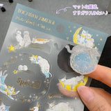 A sticker sheet with cute cats exploring and resting all throughout the starry night designed by Tokoro Komugi who is known for their soft style of illustration featuring animals! Perfect for decorating letters, notebooks, and more!