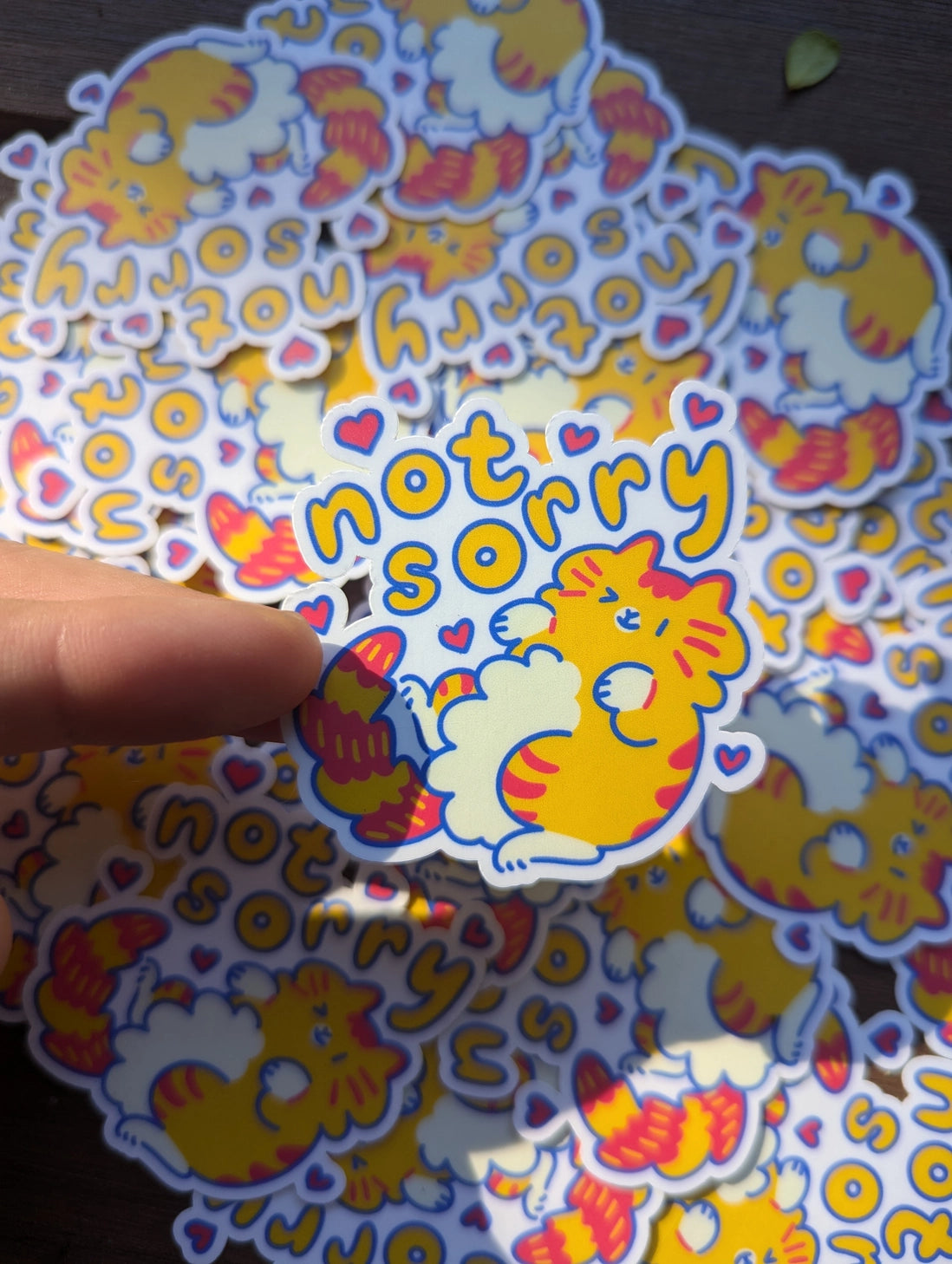 This 2" vinyl waterproof sticker features a playful cat rolling on its back and winking, paired with the bold text "Not Sorry." Perfect for those moments when you just have to let the world know you’re doing things your way, this sticker is both durable and stylish. Whether you stick it on your laptop, water bottle, or anywhere else, this sassy feline is sure to add a touch of attitude to your day!